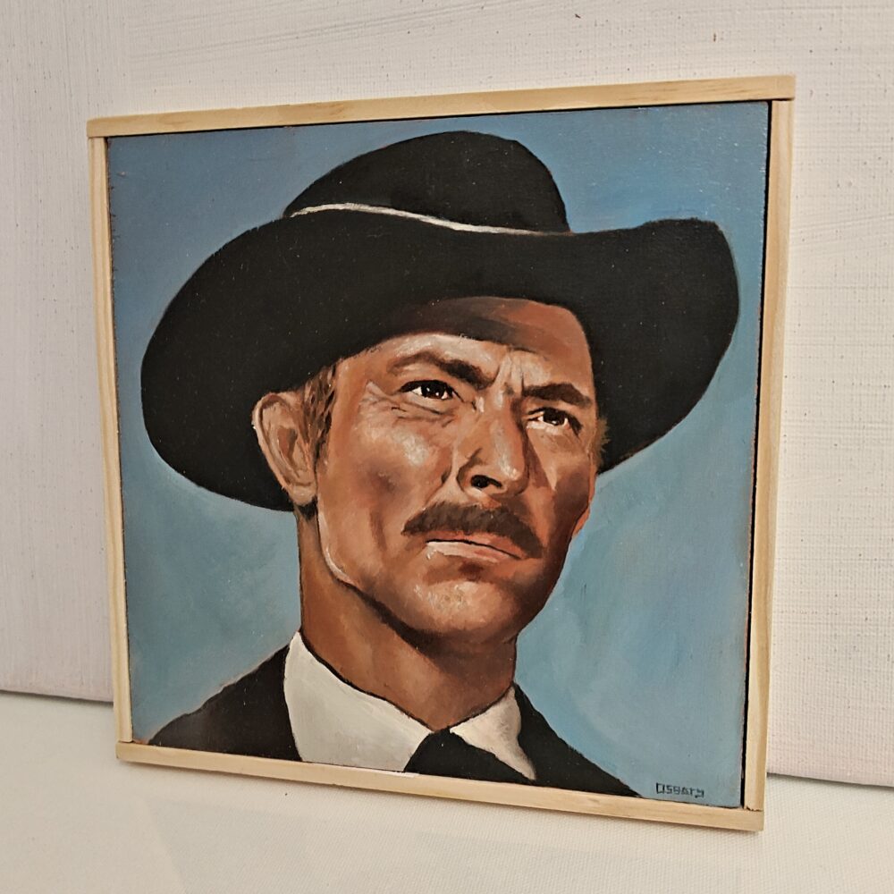 Side angle view of framed oil painting showing the depth of the wood panel and natural timber frame. Close-up detail of the brushwork texture on the Lee Van Cleef portrait.