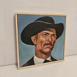 Side angle view of framed oil painting showing the depth of the wood panel and natural timber frame. Close-up detail of the brushwork texture on the Lee Van Cleef portrait.