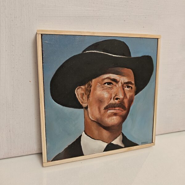 Side angle view of framed oil painting showing the depth of the wood panel and natural timber frame. Close-up detail of the brushwork texture on the Lee Van Cleef portrait.