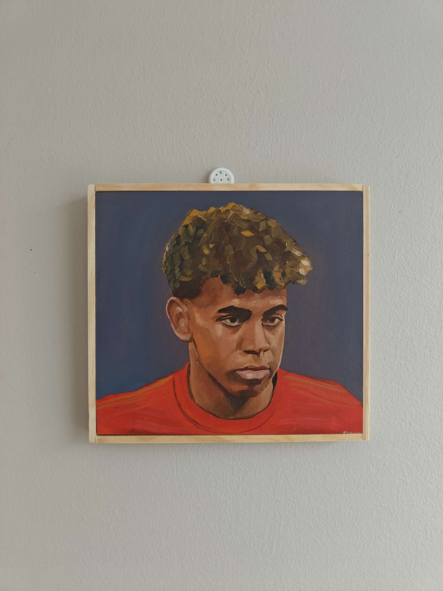 Angled side view of the Lamine Yamal football portrait showing the wood panel depth.