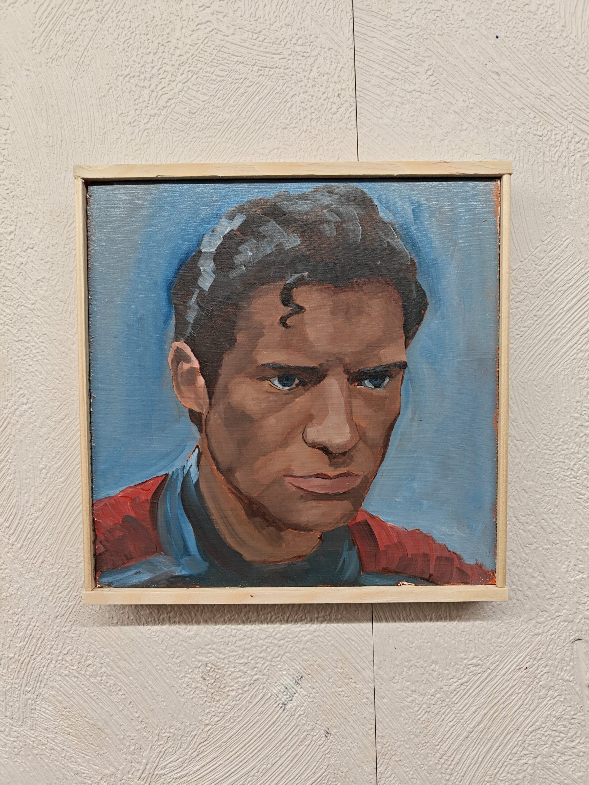 Hand-painted Superman David Corenswet art in a wooden frame displayed on a textured studio wall.